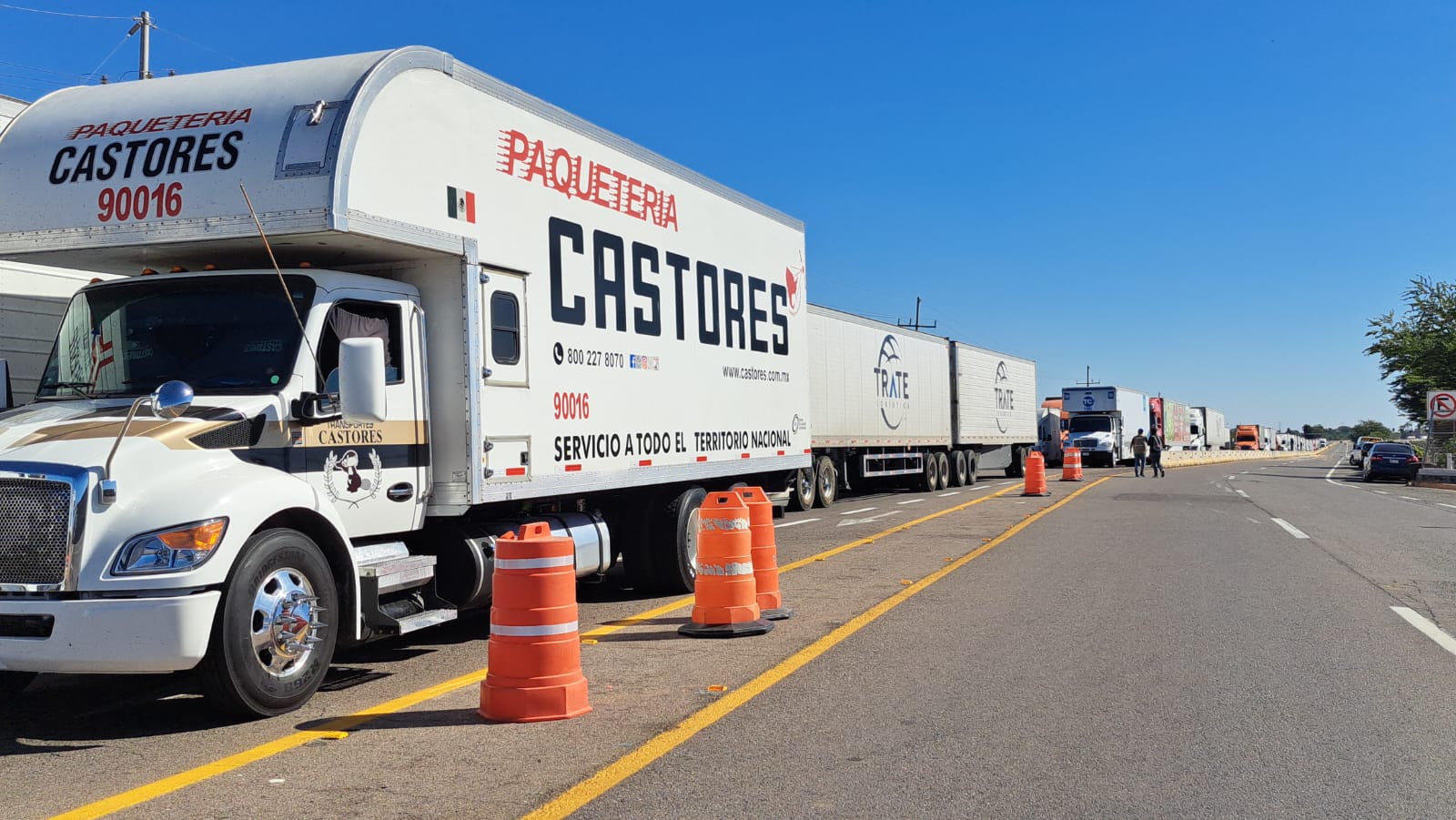 Camión detenido junto a dos tambos naranjas de precaución en carretera de Sinaloa por bloqueo de casetas