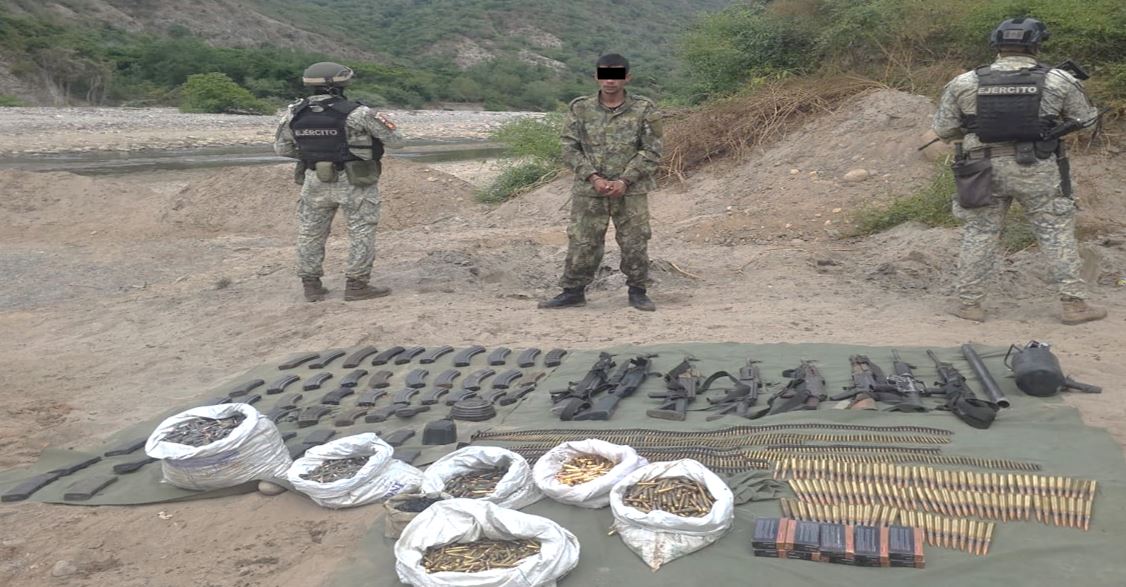 Dos elementos del ejercito junto a una persona detenida y en el suelo armas y demás objetos que se aseguraron