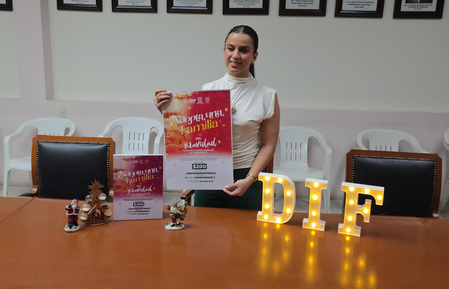 Directora de del DIF de Salvador Alvarado, Rosalinda Cruz Huitrón con un cartel del anuncio de 'Adopta una familia'