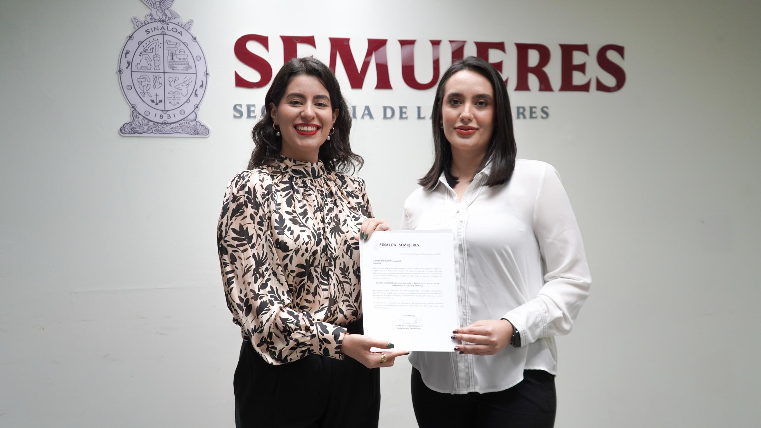 Ana Francis Chiquete Elizalde sosteniendo un documento junto a Karen Daniela Morán Valdez