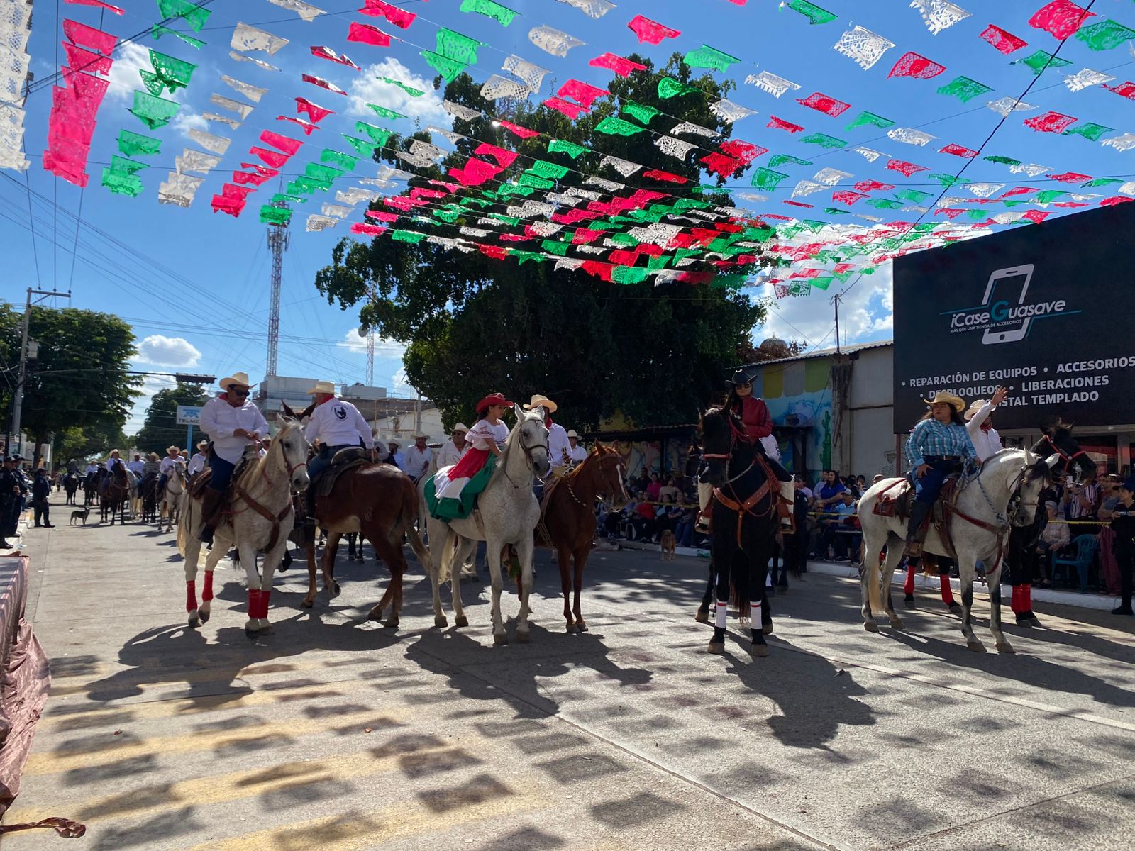 Personas a bordo de caballos desfilando