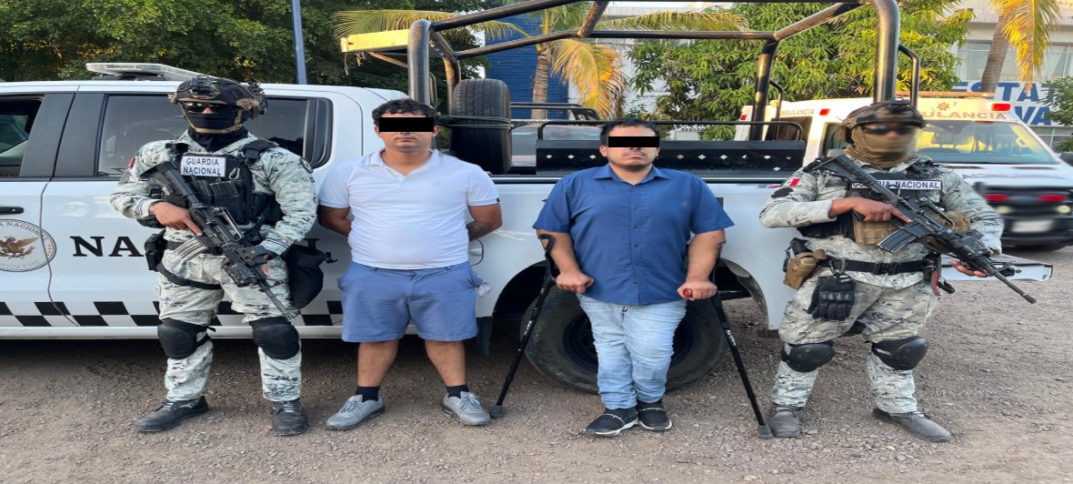 Elementos de la marina con 2 personas detenidas, junto a una unidad de la Guardia Nacional