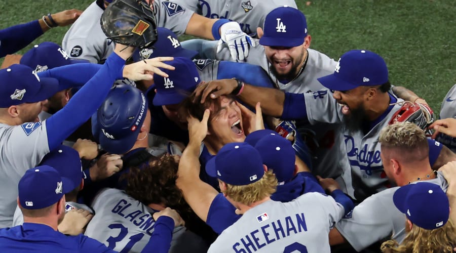 Dodgers celebrando su victoria mientras apapachan a Yamamoto