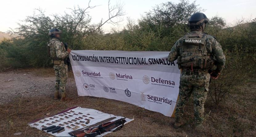 Elementos del ejército junto a una lona y armamento asegurado