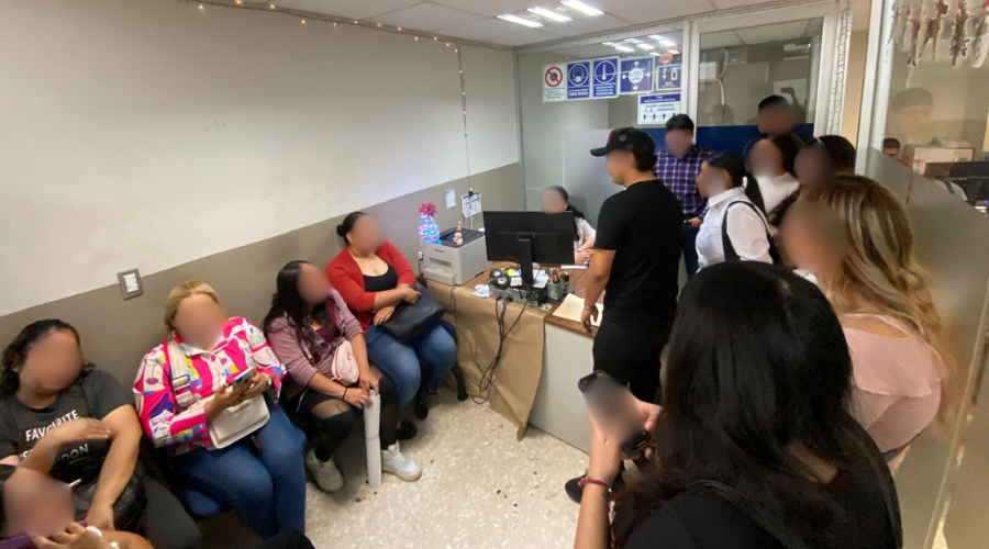 Personas empleadas de casino clausurado en Los Mochis dentro de las oficinas de la Dirección de Trabajo y Previsión Social Zona Norte, algunos están sentados y otros parados junto a la computadora de operación