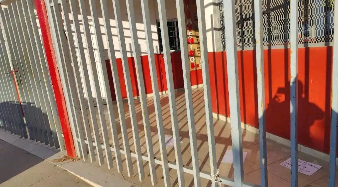 Rejas color gris de la entrada de una escuela color naranja