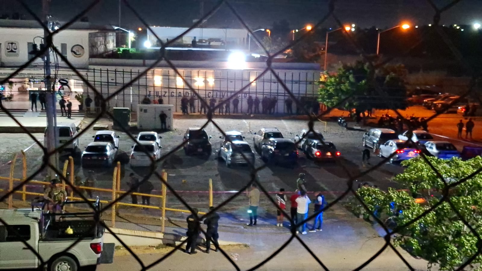 Estacionamiento de una institución atrás de unas rejas luego de una explosión