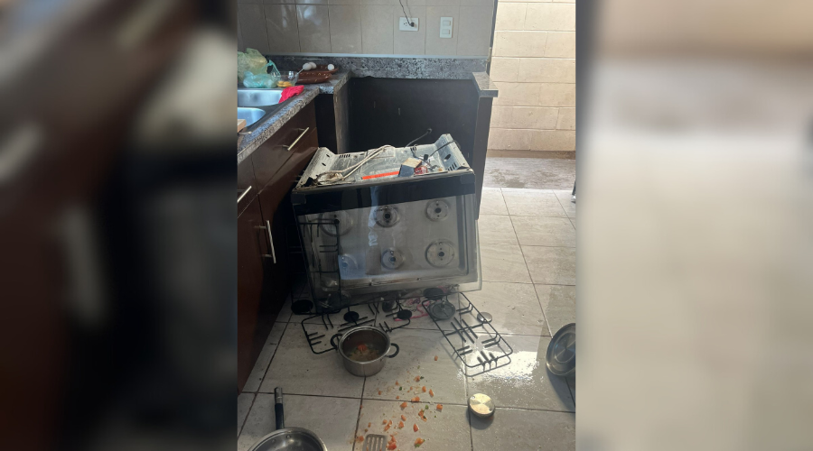 Cocina de un domicilio, con la estufa fuera de su lugar debido a una explosión de gas, casos con comida dentro tirados en el suelo