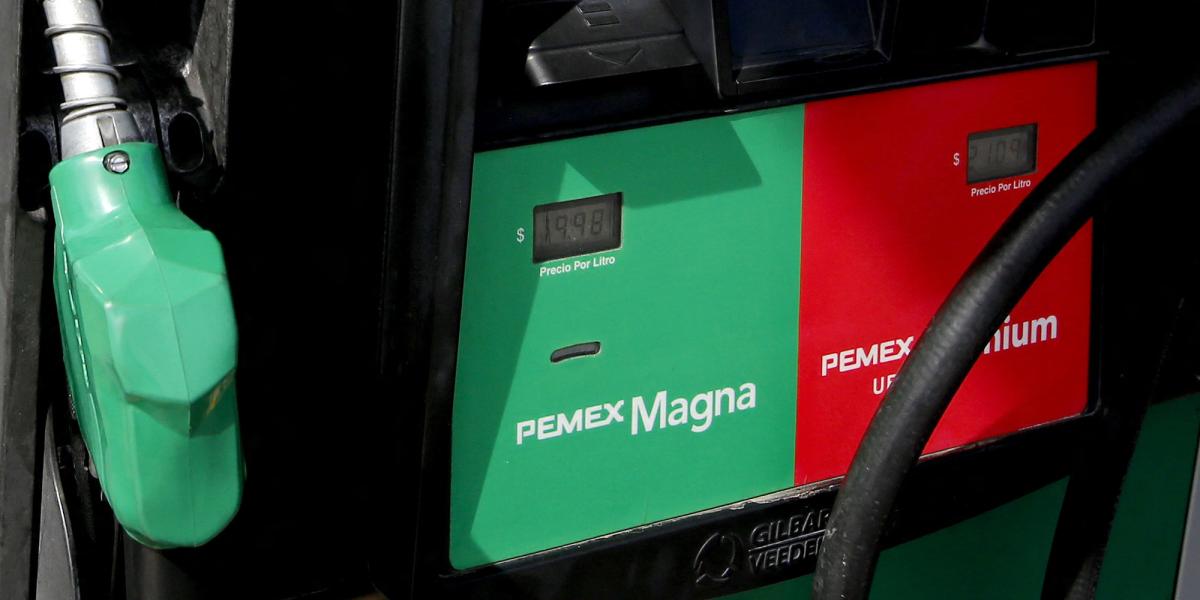 Manguera de gasolina color verde en una estación de servicio, aparecen dos cuadros uno de color verde (gasolina Magna) y el otro recuadro es rojo (gasolina Premium)
