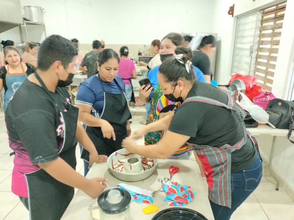 Tres personas con utensilios de repostería en taller
