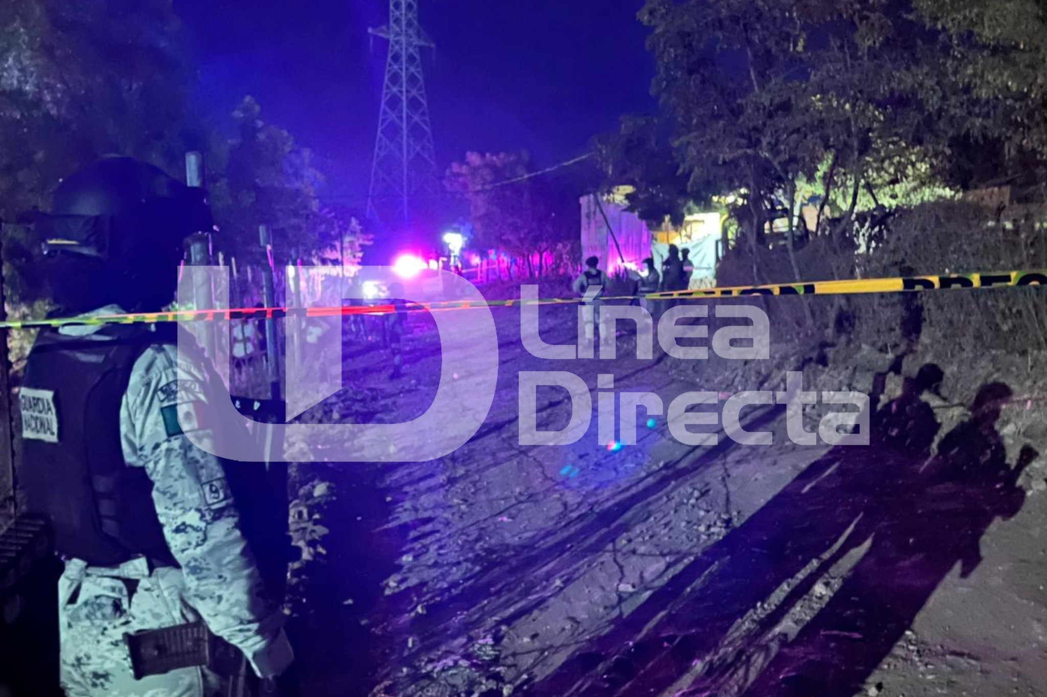 elementos de la Guardia Nacional junto a una unidad movil y una cinta amarilla de precaución resguardando la zona