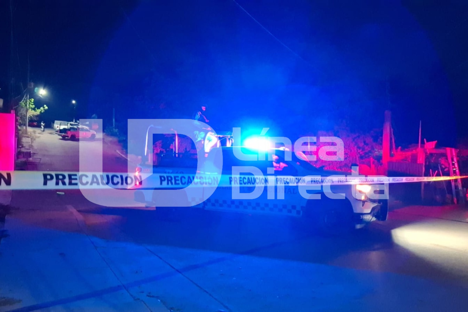 Cinta amarilla de precaución junto a una patrulla de Guardia Nacional con las sirenas prendidas