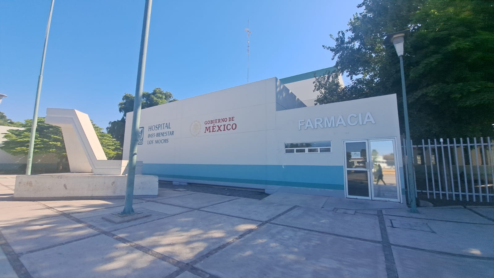 Parte exterior del Hospital IMSS-Bienestar de Los Mochis, donde se ven los logos de la institución y el gobierno de México además de la localización de la farmacia