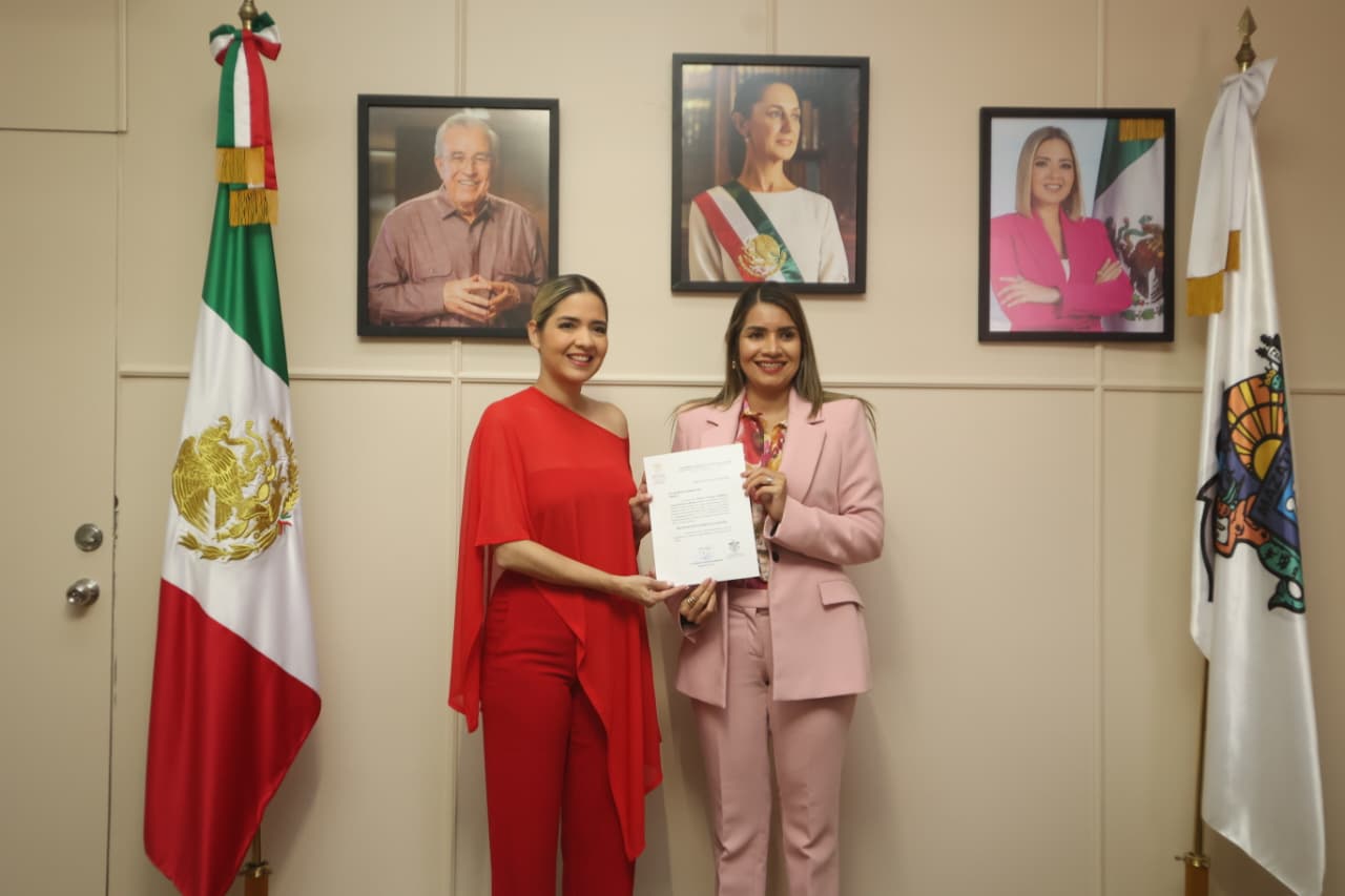 Estrella Palacios sosteniendo un documento junto a Ana Marcela Herrera