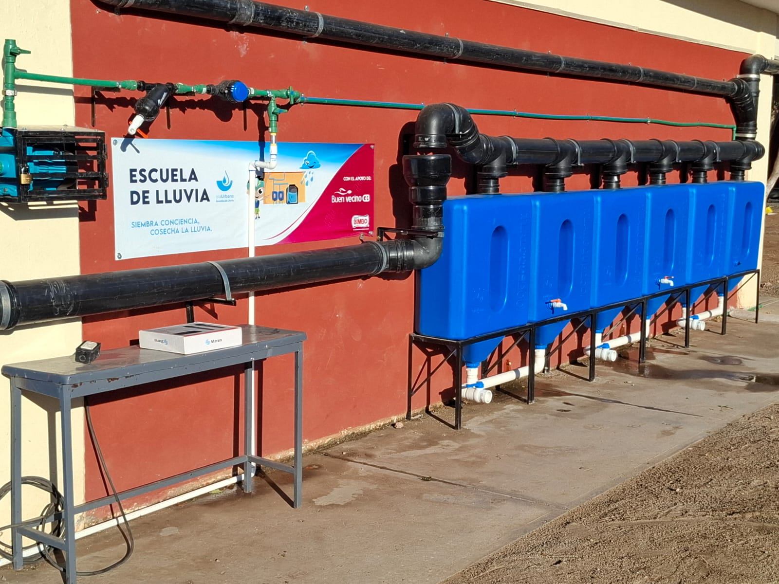 sistema de captación de agua de lluvia instalado en una pared de una secundaria