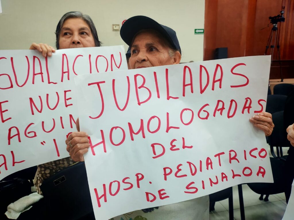 Persona jubilada del Hospital Pediátrico con una cartulina en manifestación