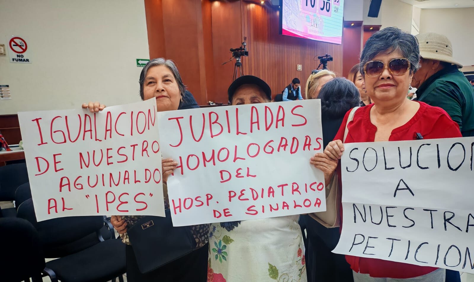 Personas con cartulinas en manifestación en el Congreso de Sinaloa