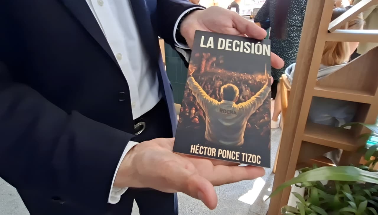 Héctor Ponce presenta su obra “La Decisión”,: en la imagen se ve al autor sosteniendo su libro