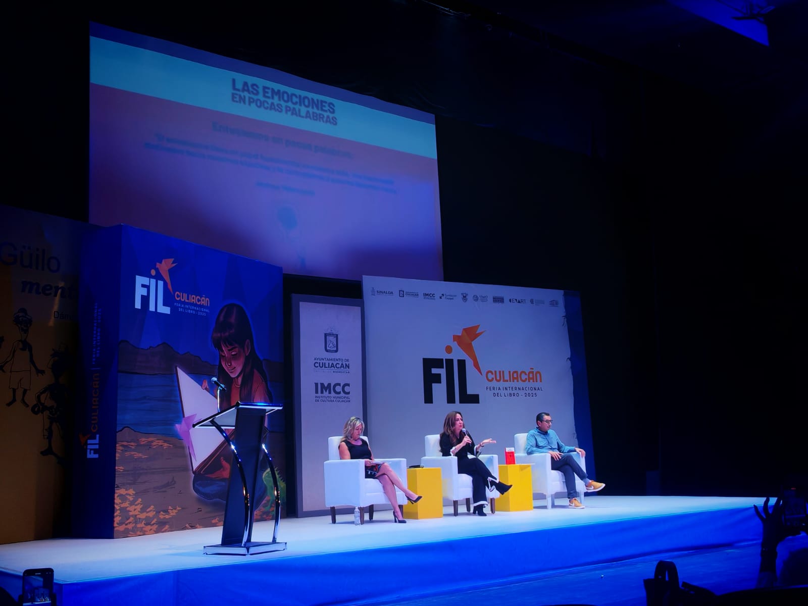 Autores en un escenario presentando su libro