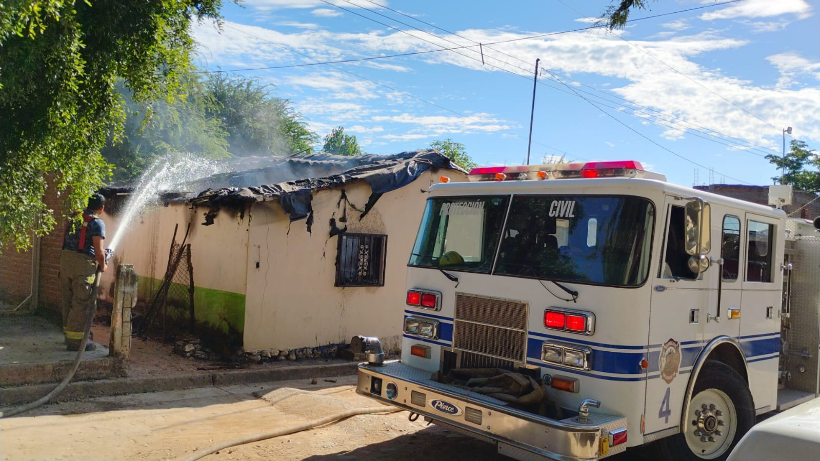 Camión de bomberos junto a casa incendiada en San Ignacio