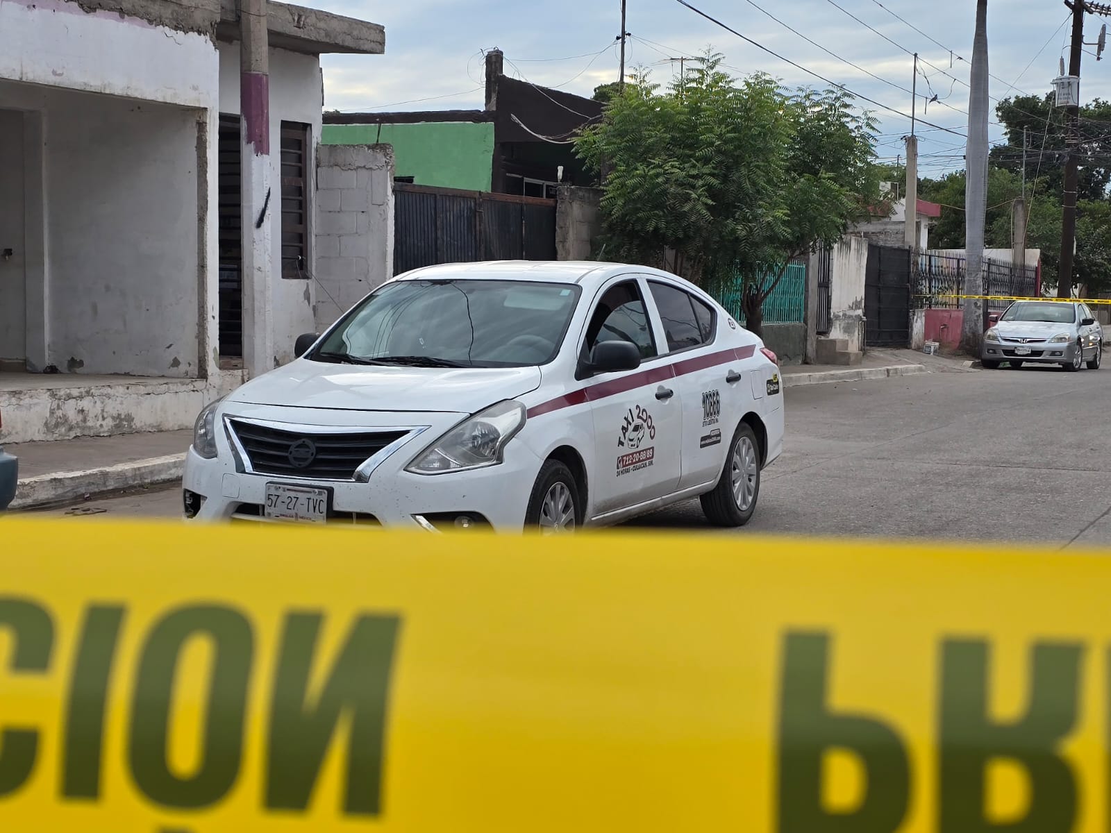 Taxi en medio de una calle y una cinta amarilla