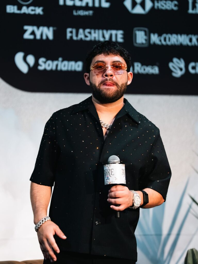 Luis R Conríquez en un evento sosteniendo un micrófono