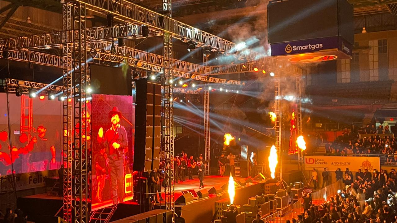 Imagen de un concierto celebrado en un auditorio, con luces y una pantalla gigante además de personas observando al artista