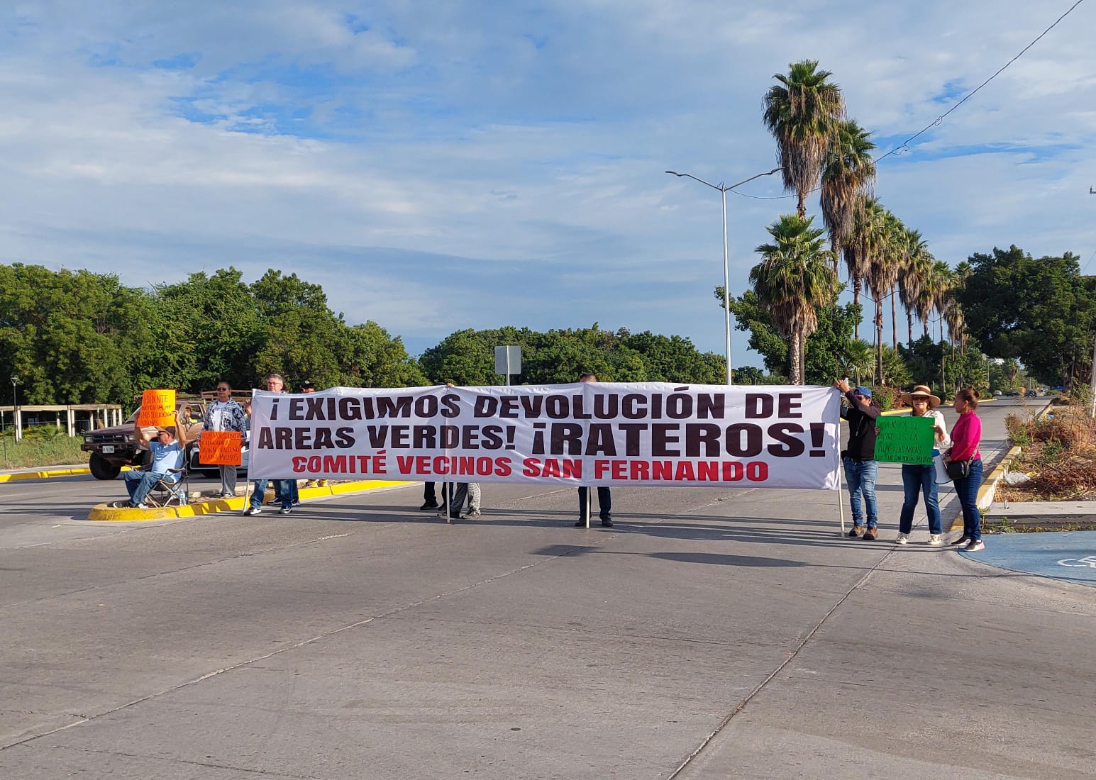 Manifestación de vecinos del San Fernando en Los Mochis, están bloqueando una calle y sosteniendo una lona con la leyenda de sus exigencias