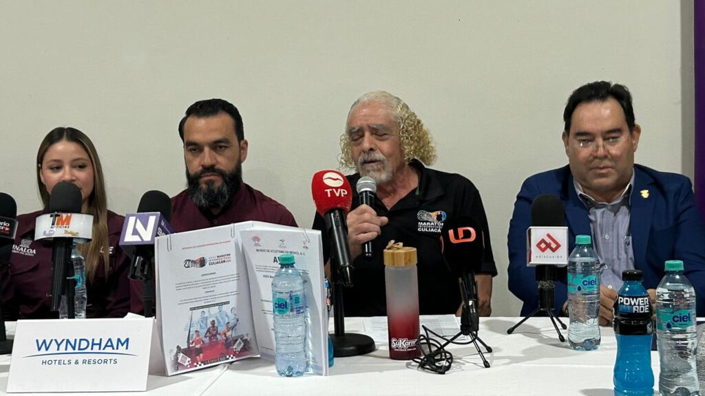 comité organizador sentado en una conferencia de prensa