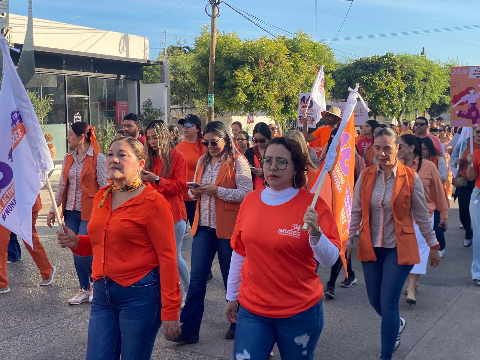 Personas marchando con playeras naranjas