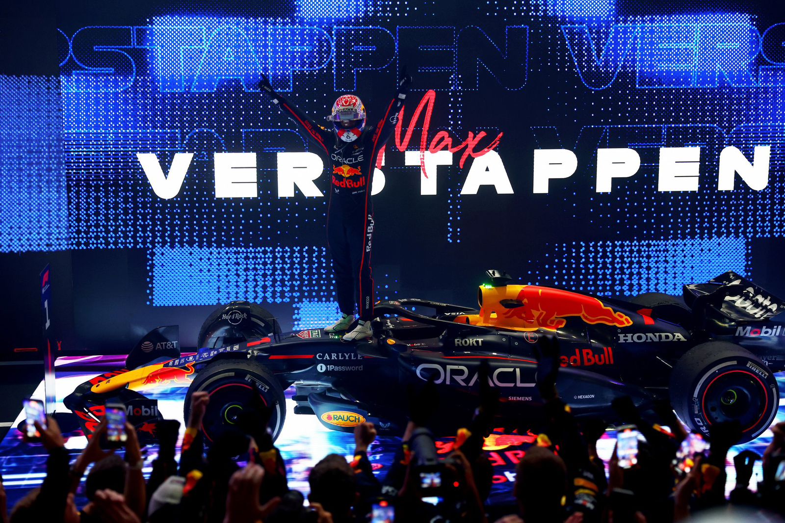 Max Vestappen en el podio del GP de Qatar parado sobre su auto mientras celebra con las manos levantadas