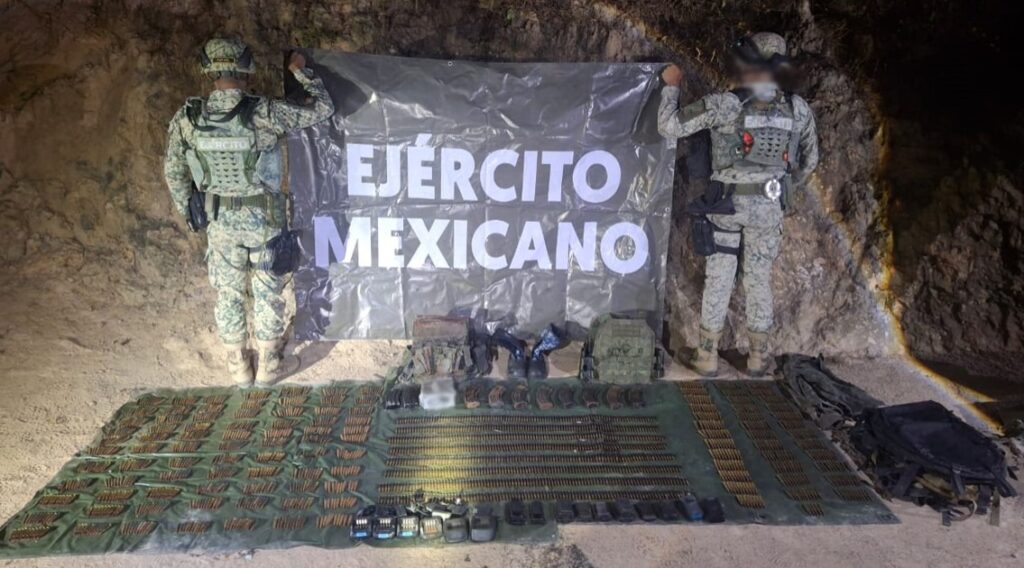 Militares sosteniendo un banner de espaldas y en el piso cosas que aseguraron