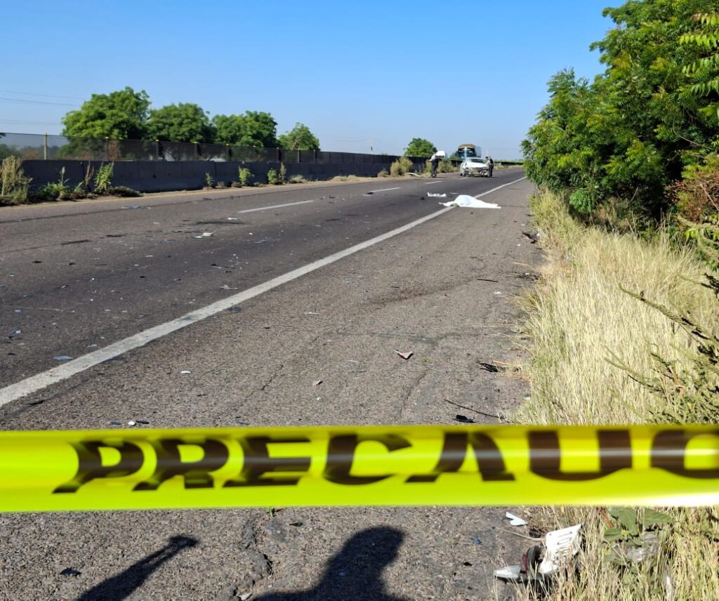 Cinta amarilla de precaución junto a carro chocado y motociclista embestido