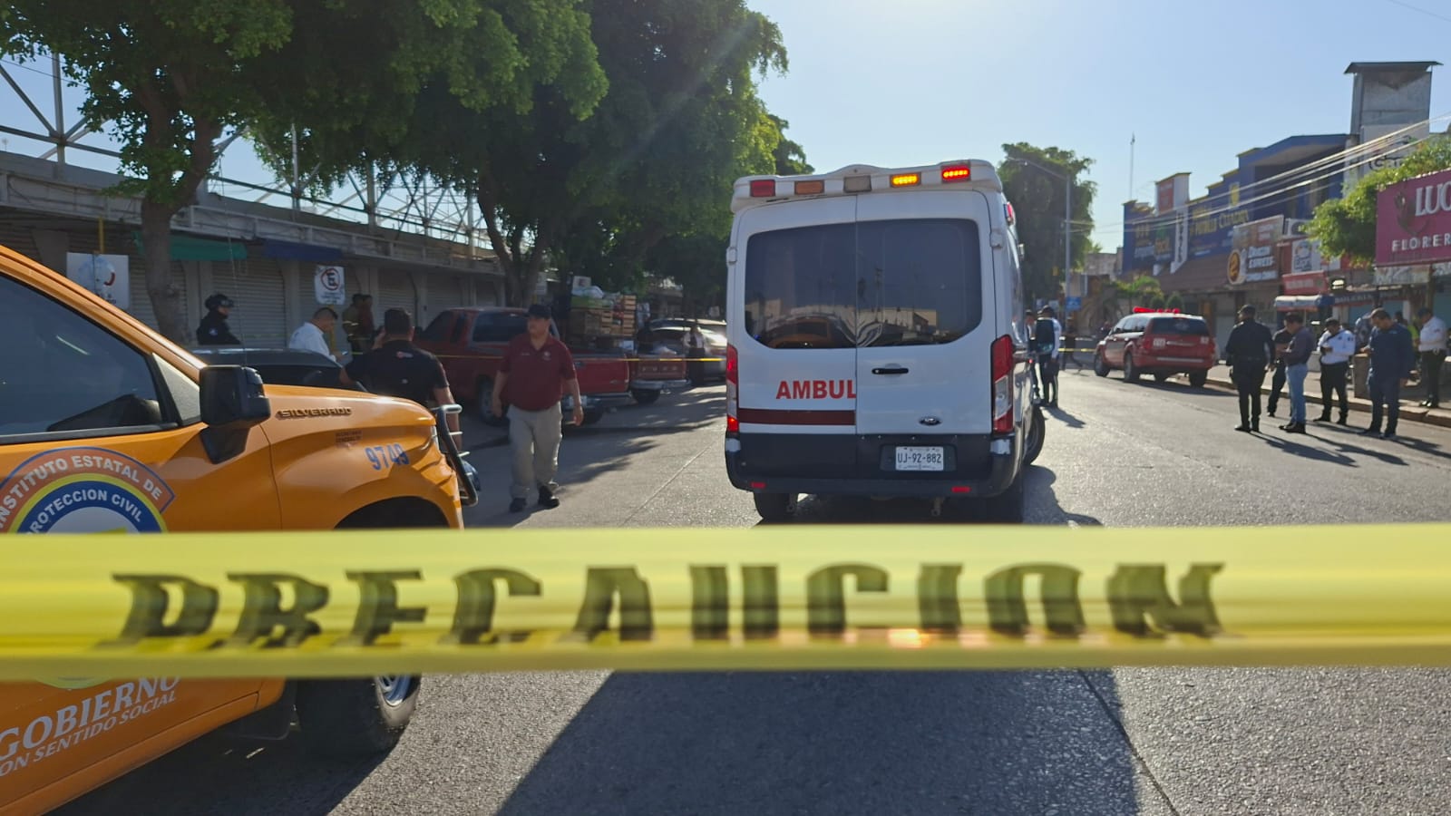 Cinta amarilla de precaución junto a una camioneta de protección civil amarilla y una ambulancia de salud Ahome