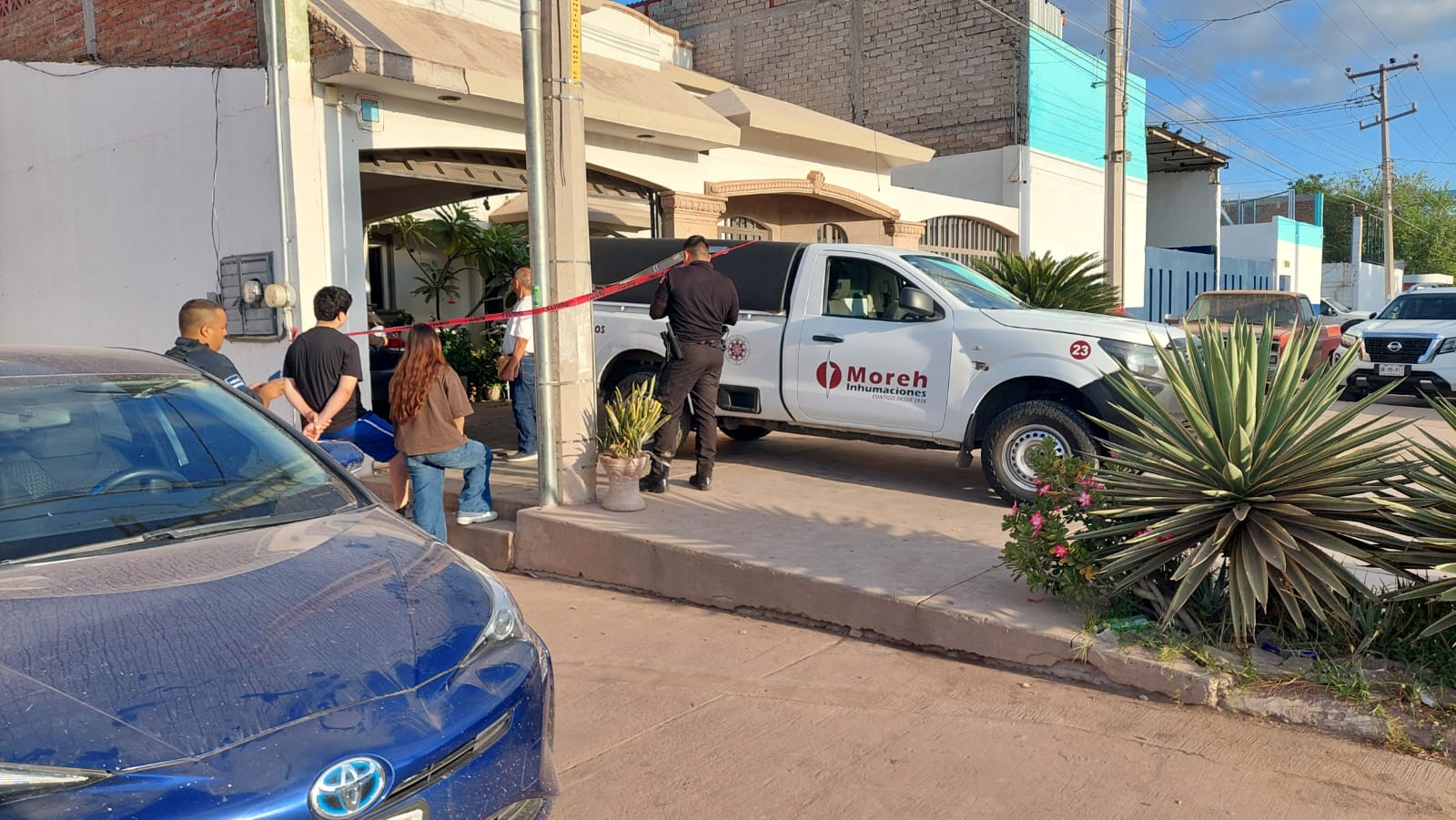 Autoridades de seguridad y una unidad funeraria a las afueras de la casa donde fallece una mujer en Los Mochis
