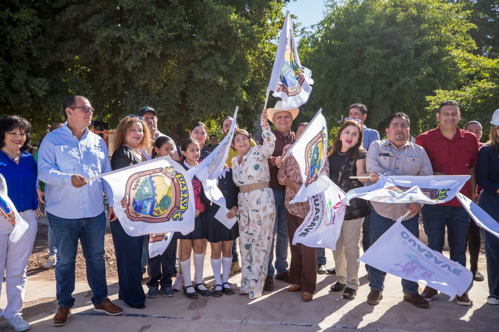 Alcaldesa de Guasave y asistentes meneando unas banderas