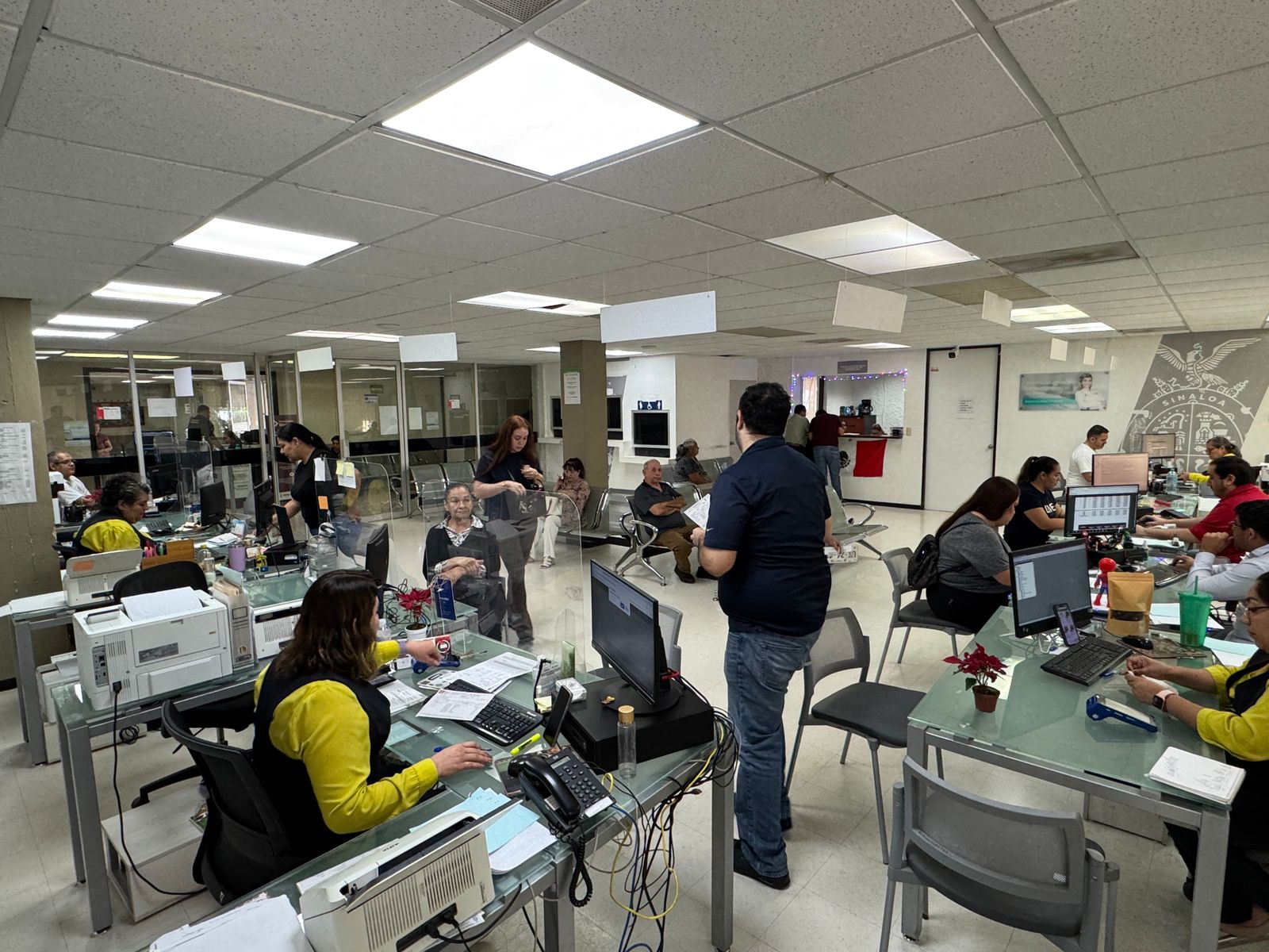 Personas en las oficinas de recaudación haciendo tramites