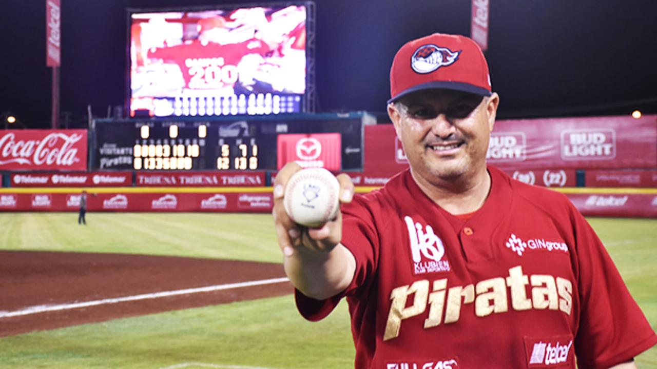 Pancho Ponches sosteniendo una pelota de beisbol en un campo