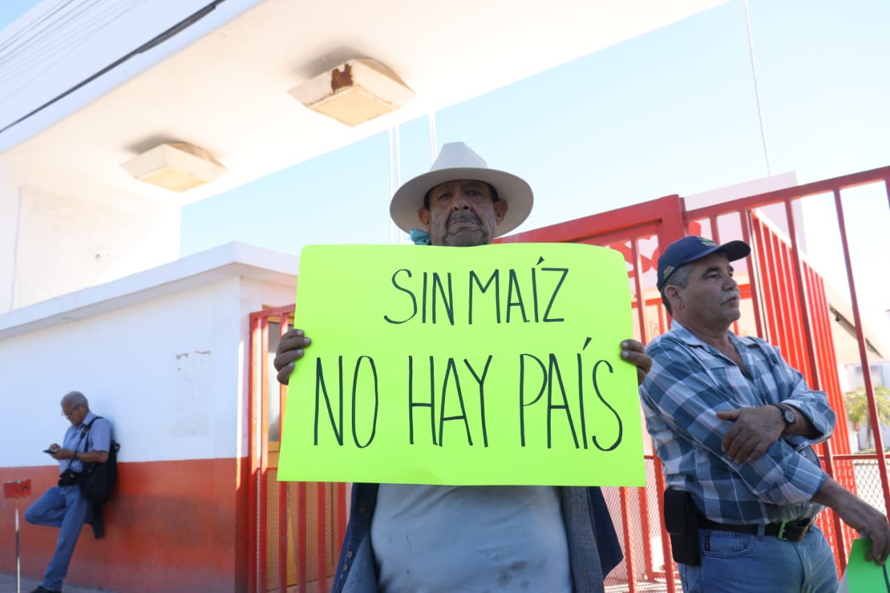Productor sosteniendo un cartelón que dice 