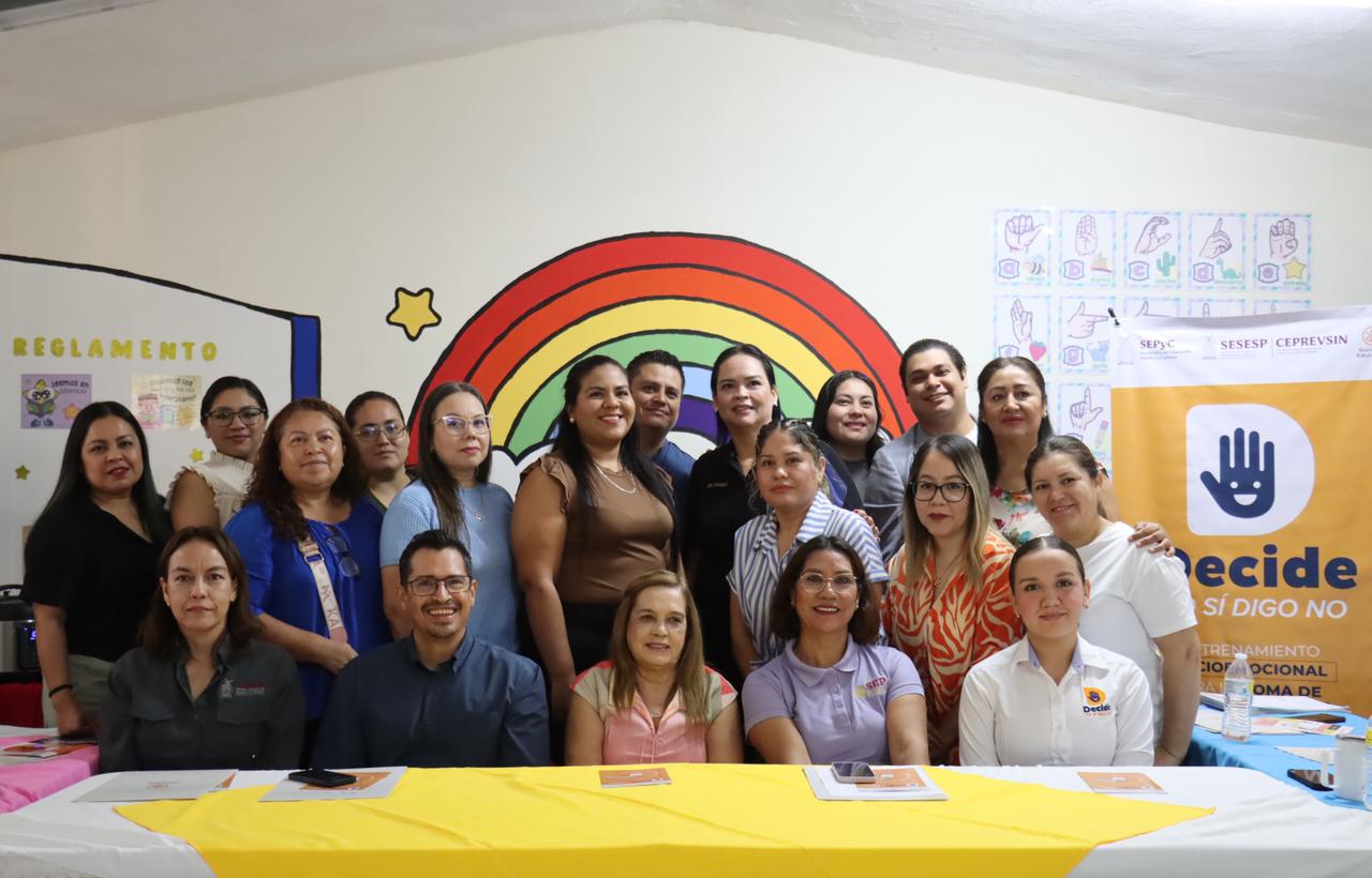 Padres de familia y autoridades de la sepyc, Sesesp y y la asociación civil Sociedad Educadora en un salón de clases posando para la foto, cinco de ellos están sentados mientras que el resto esta de pie.