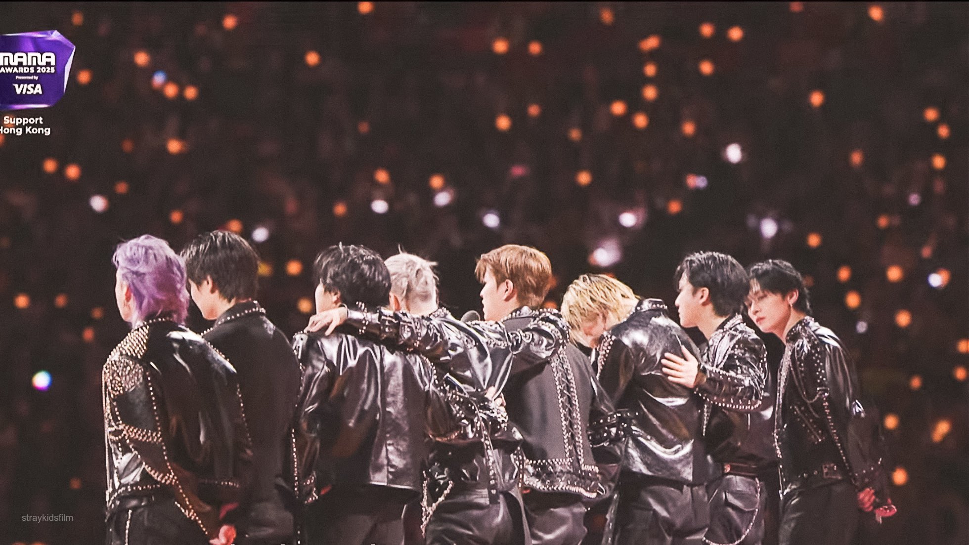 Integrantes de Stray Kids 8 hombres de espaldas recibiendo su premio vestidos de negro