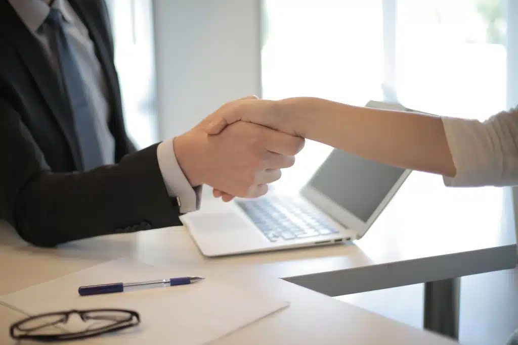 Dos personas dándose la mano en una oficina