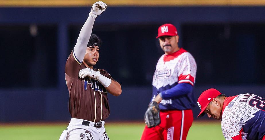 Jugadoder de baseball durante juego, con uniformes en color tinto y blanco con naranja