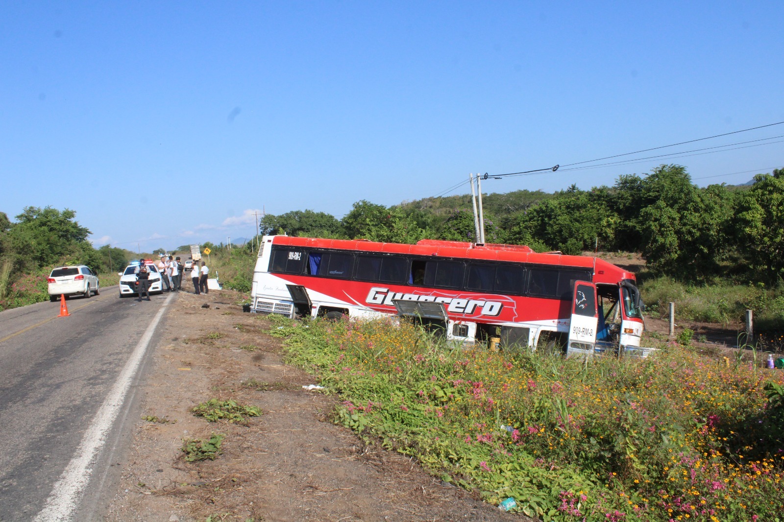 autobús rojo con blanco con guerrero fuera de la carretera chocado