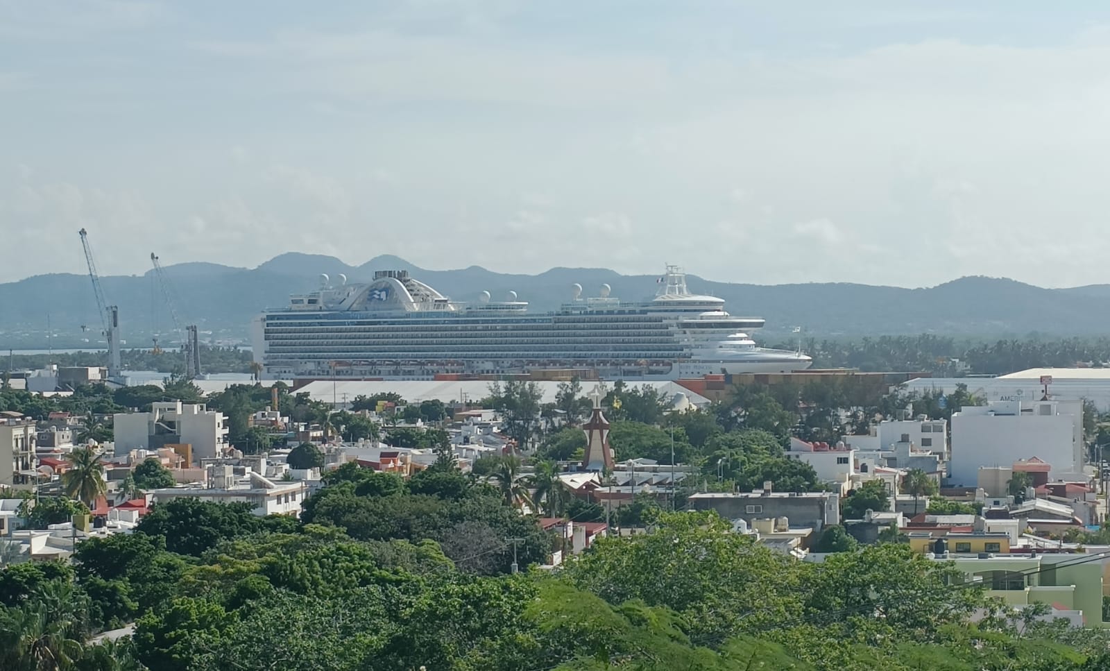 Vista de plazuela de Mazatlán con un crucero al fondo