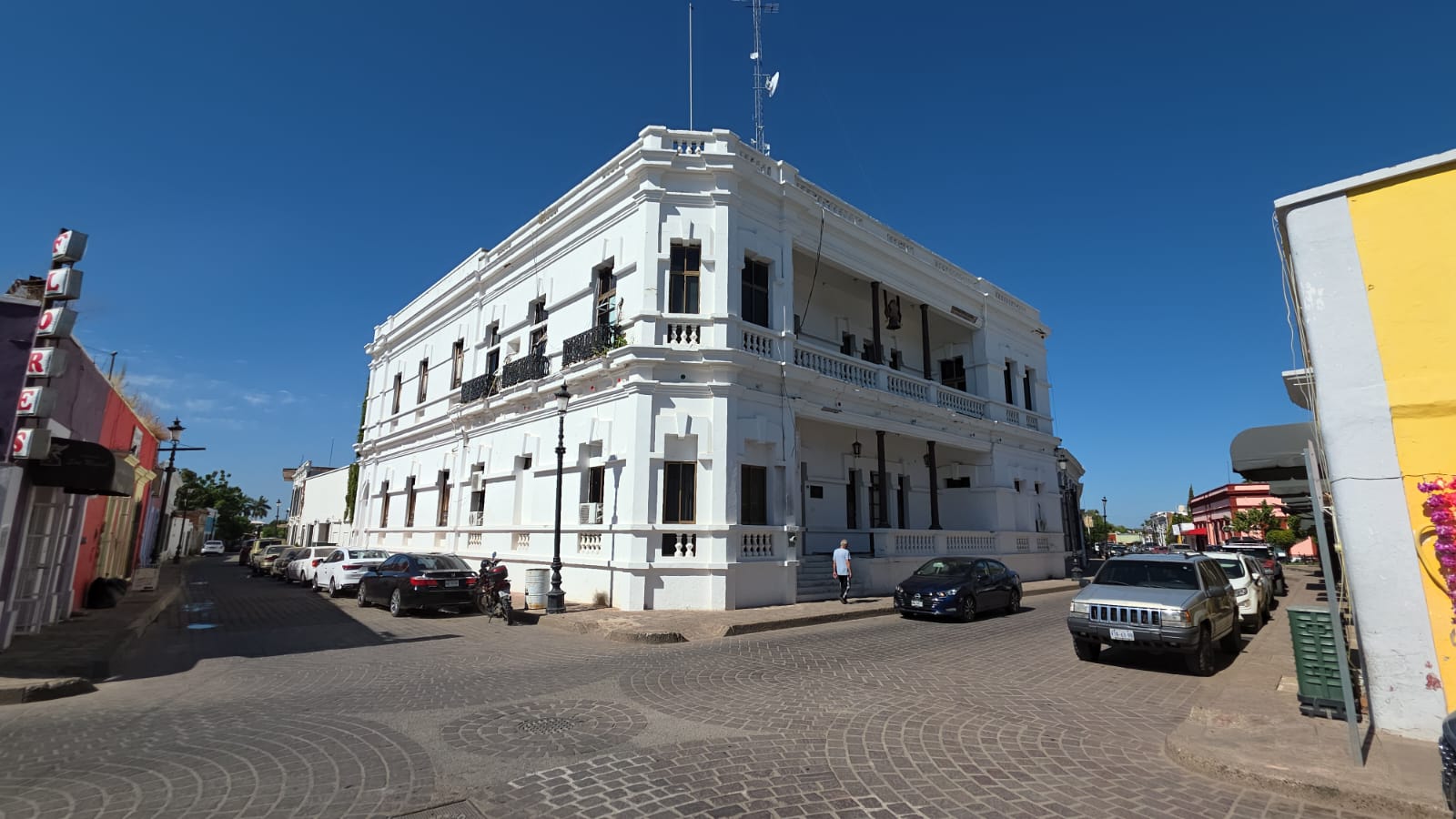 Edificio de dos pisos color blanco tomado en la esquina de una calle, este edificio resulta ser el ayuntamiento de Mocorito