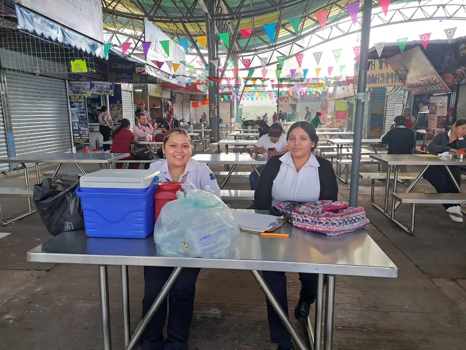 Jóvenes de la Salud sentadas en una mesa de metal en la zona 30