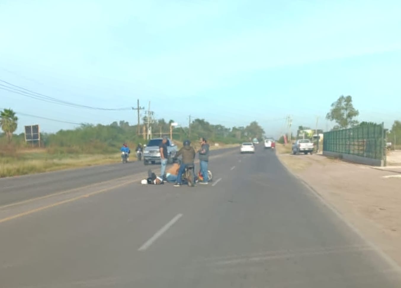 Personas en el medio de una carretera apoyando a personas que sufrieron un accidente