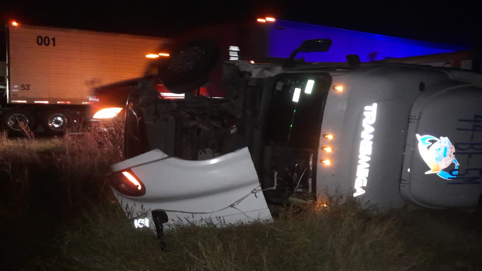 Imagen del accidente en la México 15 donde un trailer se volcó, se observa una unidad tirada fuera de la carretera y una parte del motor desparpajada