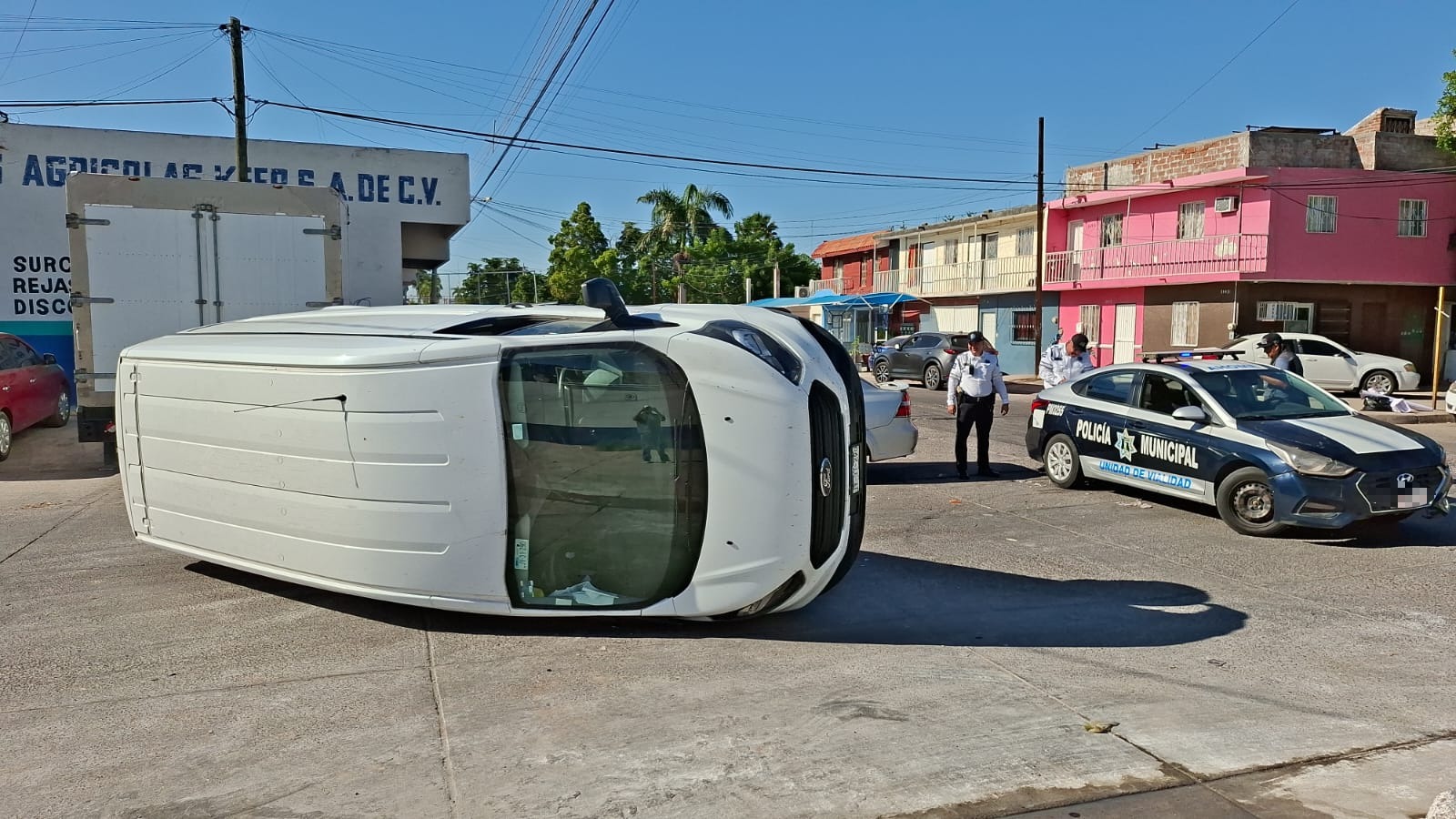 camioneta de color blanca volcada de lado en calles de Los Mochis, patrulla de Tránsitos a un costado